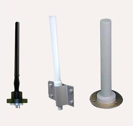 Three industrial whip antennas: black flexible, white pole-mounted with bracket, and grey pedestal-mounted.